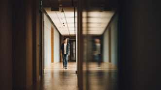Teen walking down school hallway next to blurry mirror image of teen walking down school hallway | Photo by <a href=%40chuttersnap0a14-2.html on <a href=rlc1ehzjofi6341-2.html   