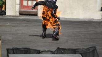 Man in motorcycle gear on fire | Greg Davis | Dreamstime.com