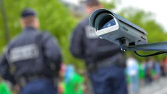 Police officers in the background with a security camera in the foreground. | 3d © Pixinoo | Dreamstime.com