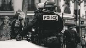 Black and white photo of police in riot gear | Photo by ev on Unsplash