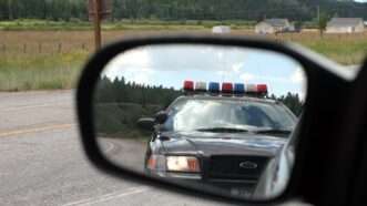 A pulled over car shows a police cruiser behind it in the side mirror | Robert Paetz /Dreamstime