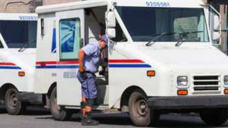 U.S. Postal Service truck and worker | Paul Weaver/ZUMAPRESS/Newscom
