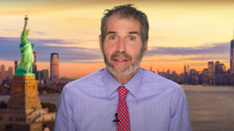 John Stossel is seen in front of the New York City skyline and Statue of Liberty | Stossel TV